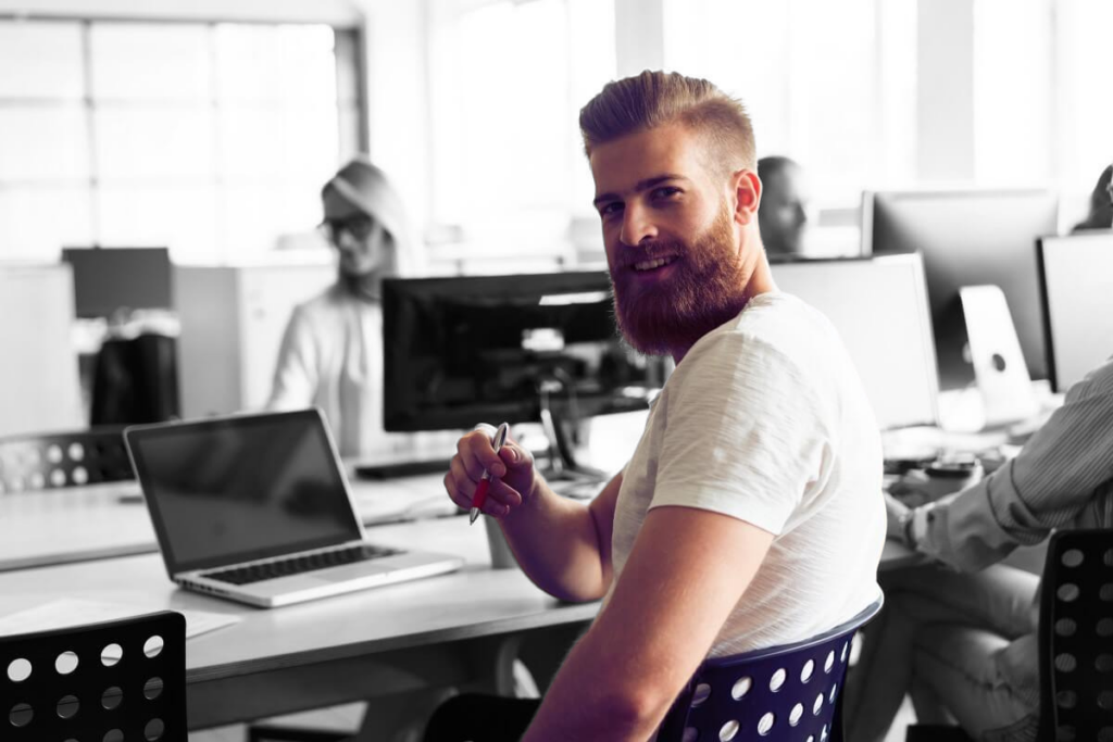 Portrait of young man sitting at his desk in the office.